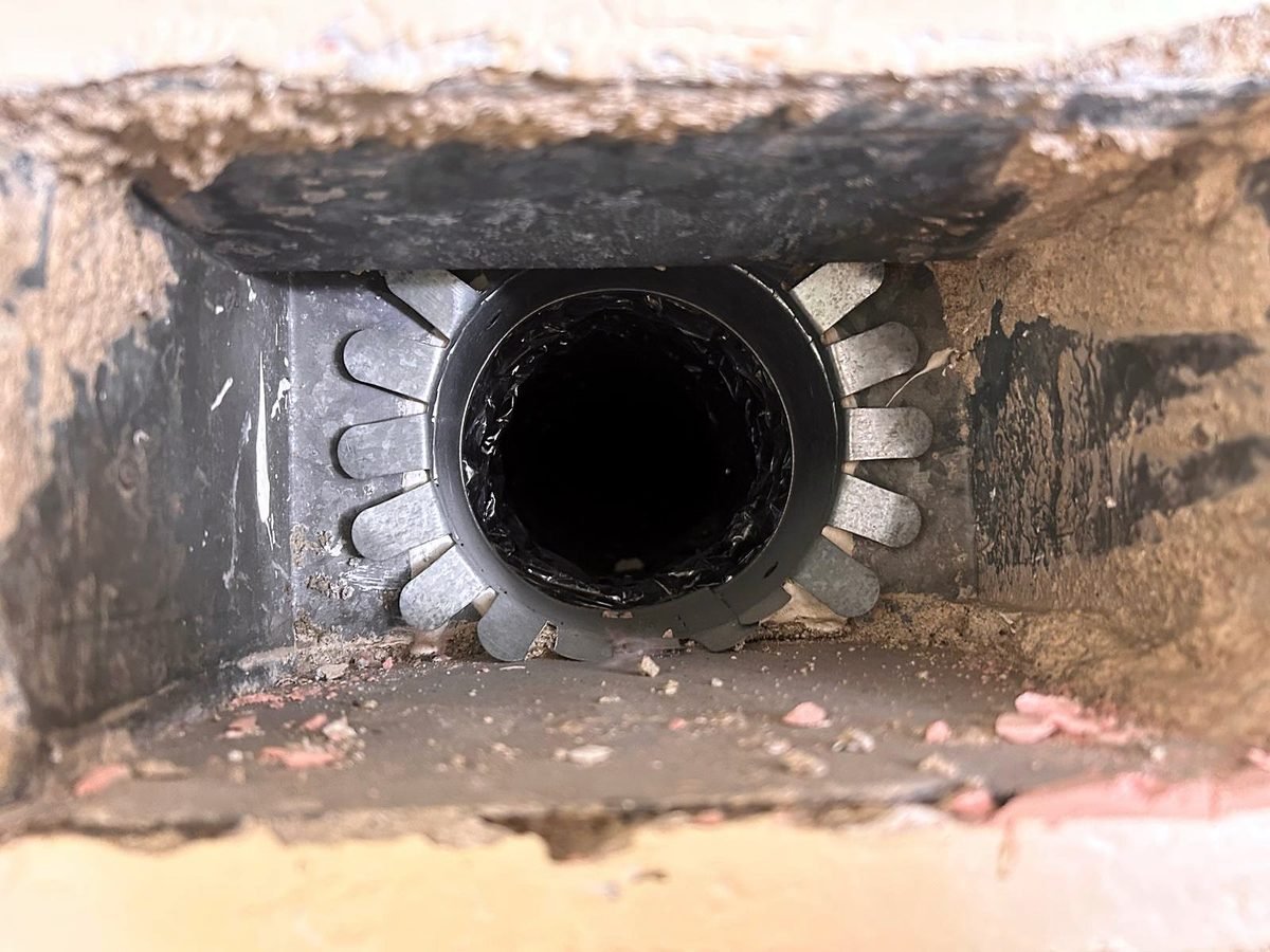 Register boot holding dirt and insulation debris
